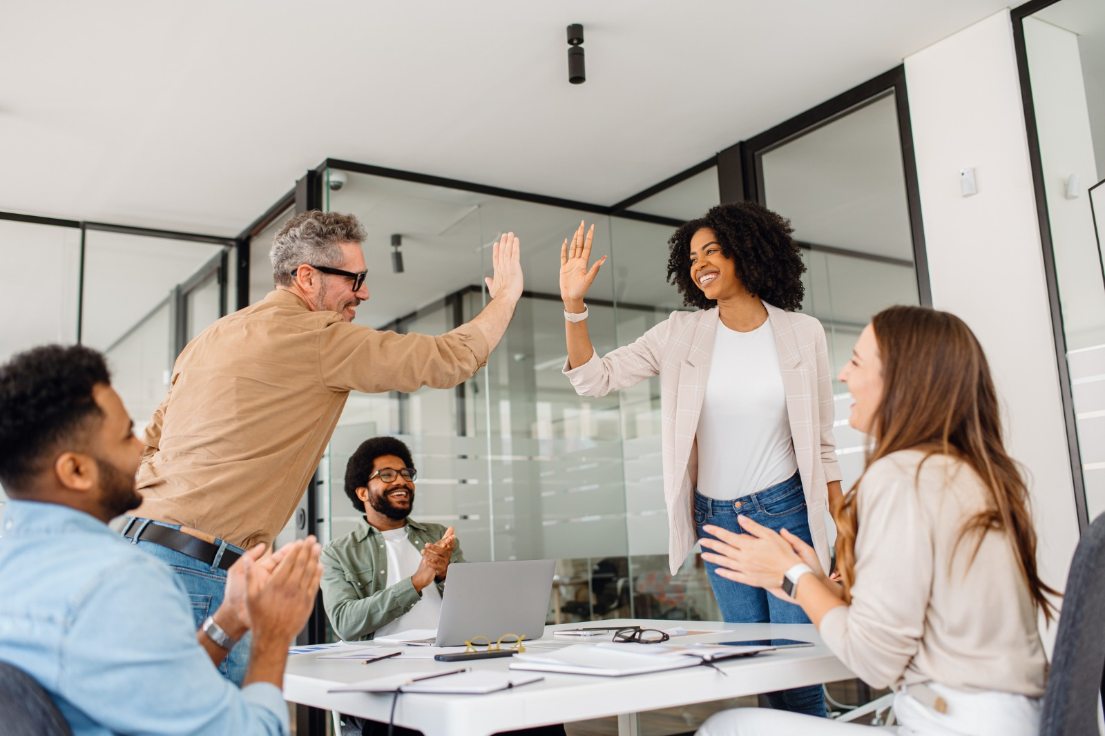 Program team celebrating results together in a bright meeting room